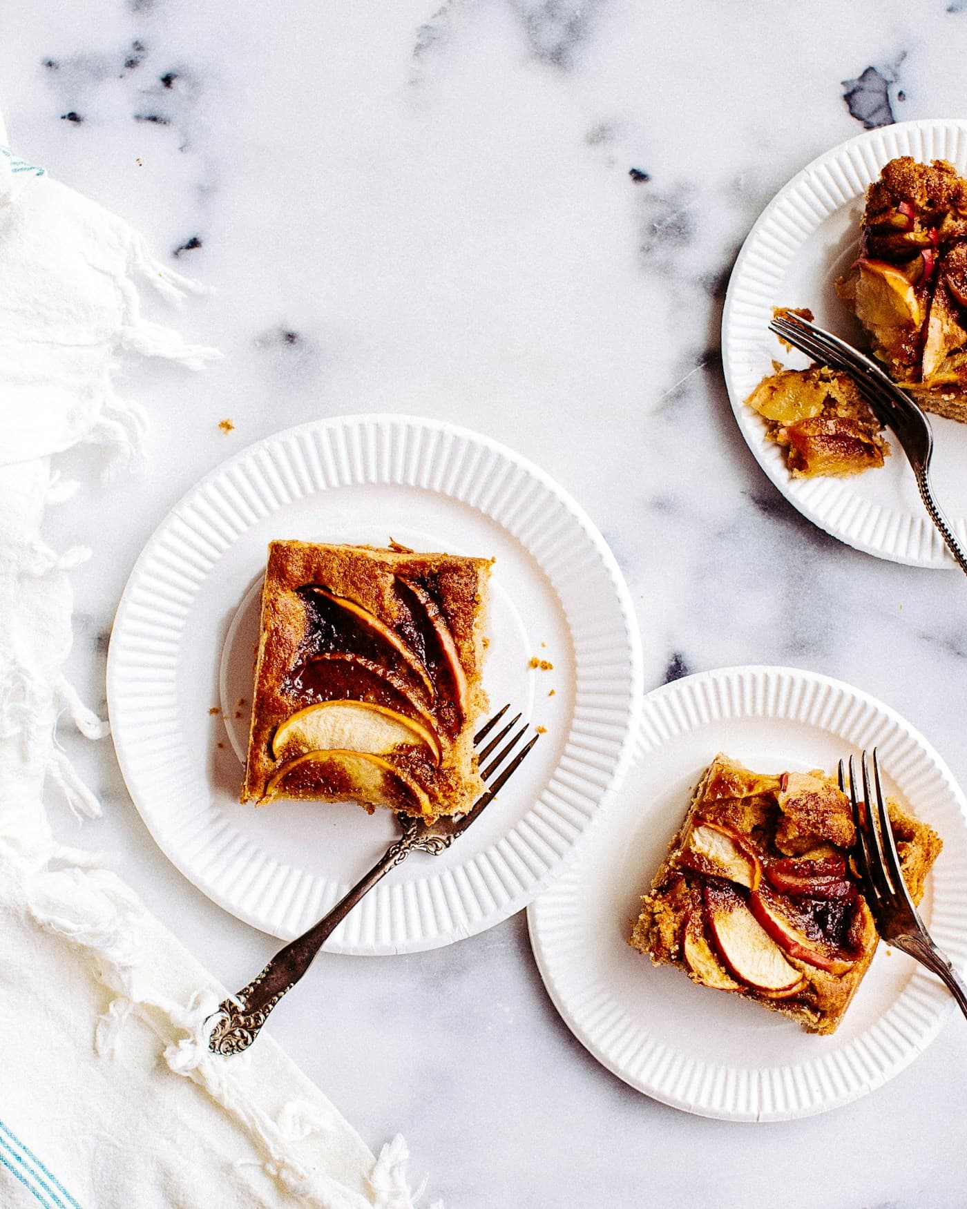 Parts de tarte aux pommes dorées dans des assiettes blanches